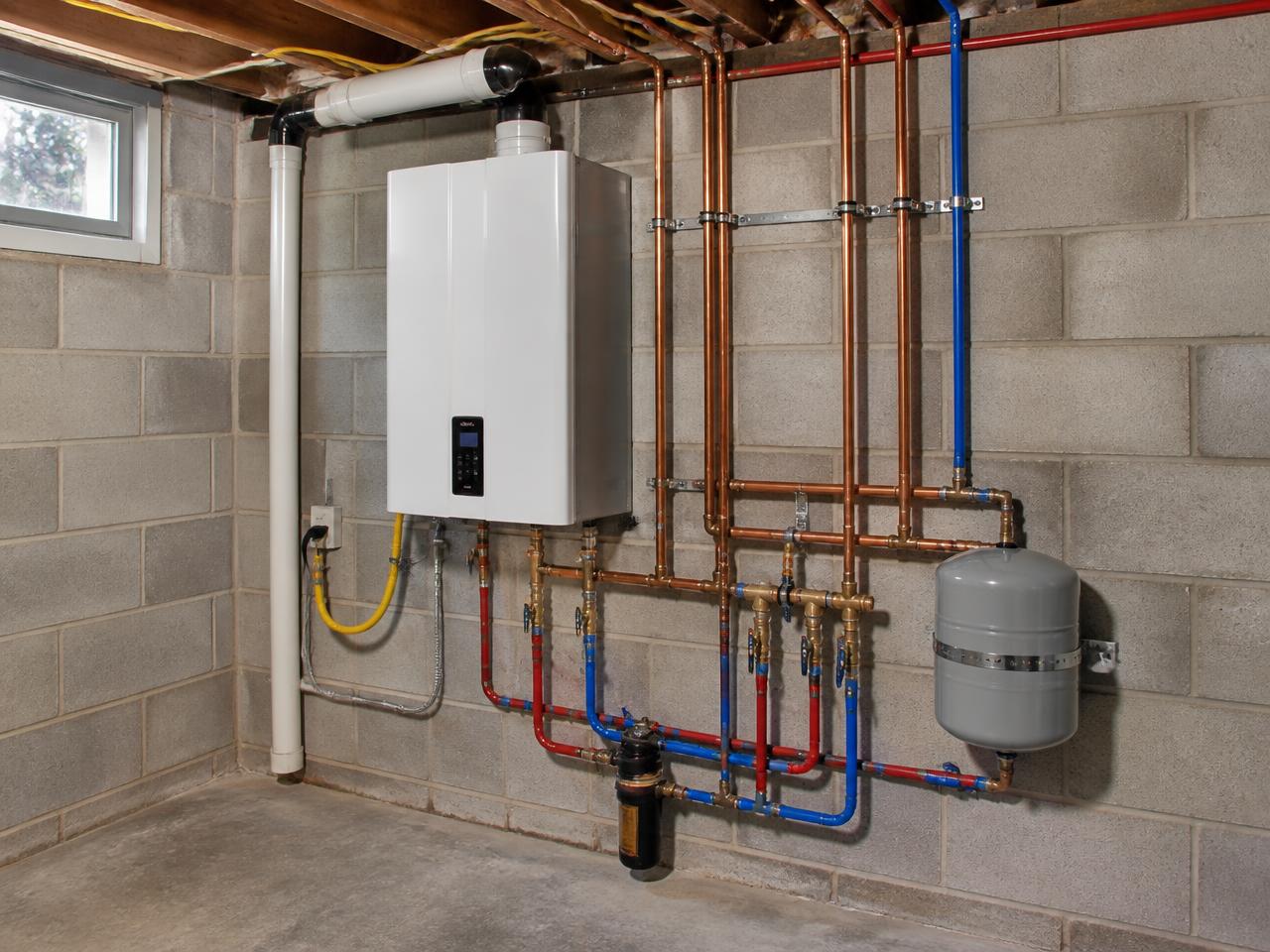Newly installed tankless water heater with tidy copper and PEX lines in a Kentucky basement